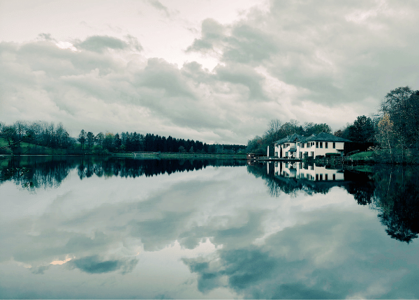 Einsamkeit: Haus am See, wolkenverhangener Himmel