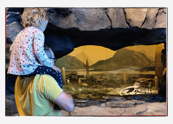 Jahresrückblick 2023: Momo auf Andreas Schultern vor einer Dinohöhle im GONDWANA