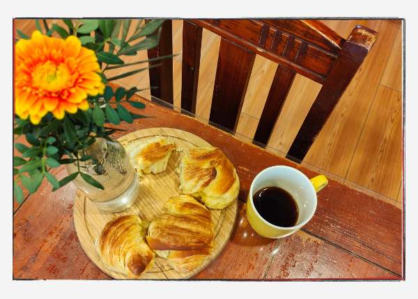 12 von 12 - März 2024 - eine Gerbera, ein Kaffee und frisch gebackene Croissants auf dem Tisch